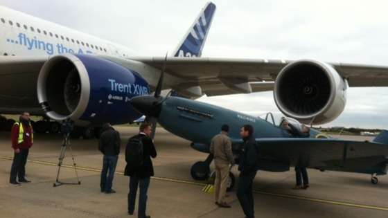 Rolls-Royce spitfire plane on runway next to Airbus A380. The spitfire is powered by a Rolls-Royce Merlin engine 