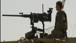 Soldier standing on watch on top of an armoured vehicle