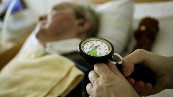 A nurse tends to an elderly man as the RCN warns of staffing cuts