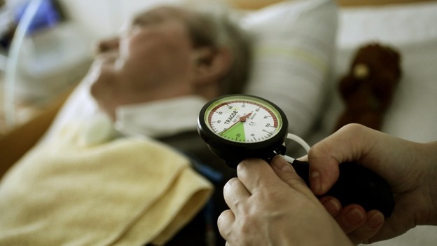 A nurse tends to an elderly man as the RCN warns of staffing cuts