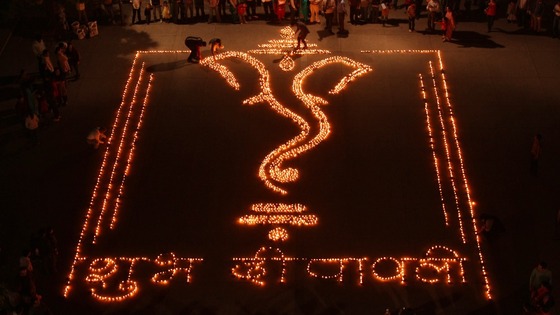 People light lamps to form the shape of Hindu god Ganesh in Chandigarh, northern India