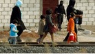 People from the northern Syrian town of Ras al-Ain walk along a train track as they attempt to cross into Turkey.