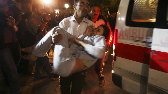 A wounded woman is carried into a hospital after Israeli air strikes in Gaza City