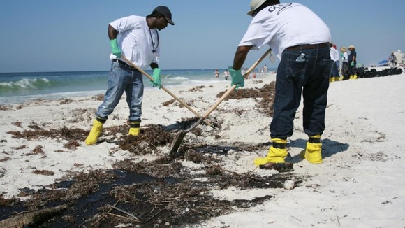 BP-contracted clean up workers remove oil from the Deepwater Horizon oil rig spill from parts of Gulf Shores beach