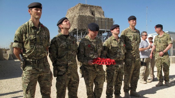British soldier lays wreath of flowers during Britain's Veterans Day ceremony at a NATO base