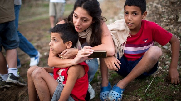 Israelis react as an Iron Dome battery intercepts a rocket fired from the Gaza Strip, near Tel Aviv 17/11/2012