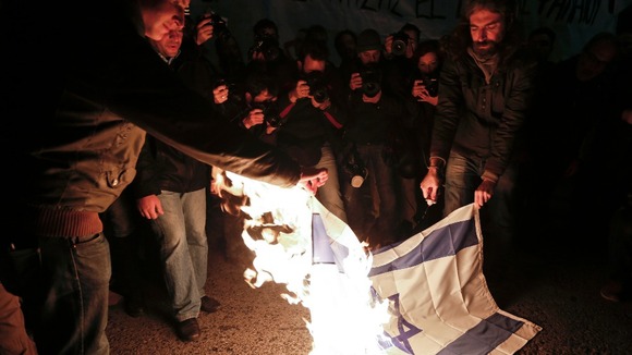 Demonstrators in Athens burn an Israeli flag