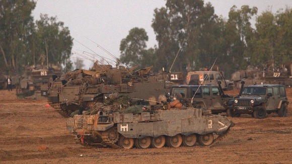 An Israeli soldier sleeps atop an armoured personnel carrier near the border of the Gaza Strip