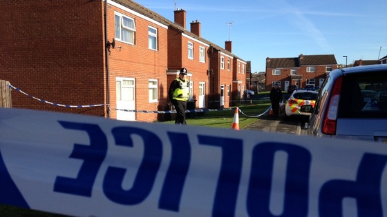 Police stand guard outside the house on Tadcaster Close