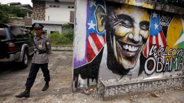 A police officer stands near a graffiti artwork welcoming President Barack Obama in Burma