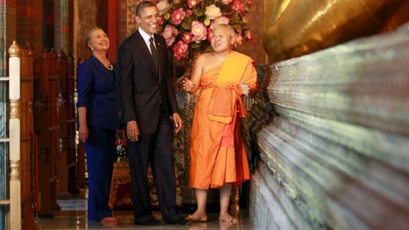 President Obama and Hillary Clinton stand with a monk at the base of the Reclining Buddha