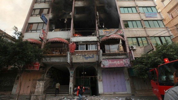 Officials inspect the damage after the Israeli strike in a building that houses media offices in Gaza City