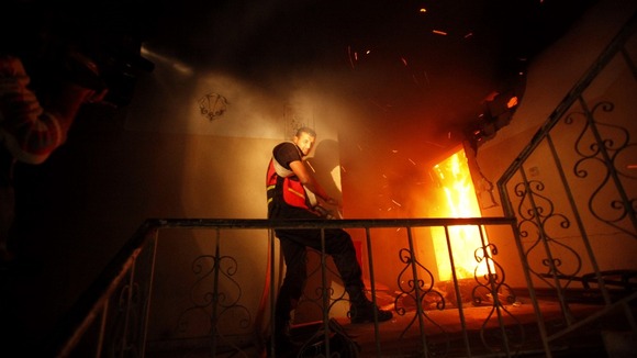 A Palestinian firefighter attempts to extinguish a fire in a building that also houses international media offices in Gaza city