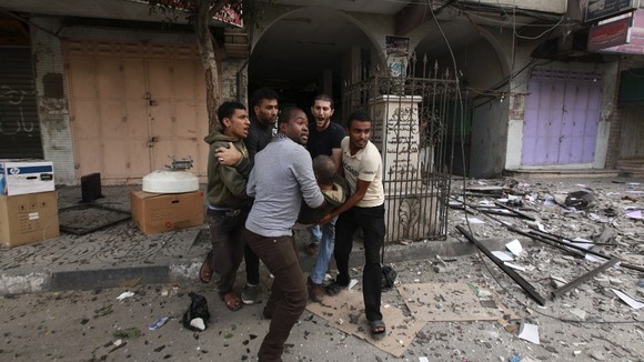 Palestinians evacuate a wounded man after an Israeli air strike on the floor of a building which houses media offices.
