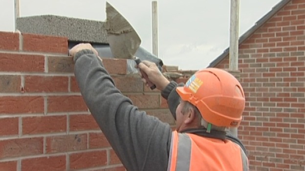 Laying bricks at the site of new homes