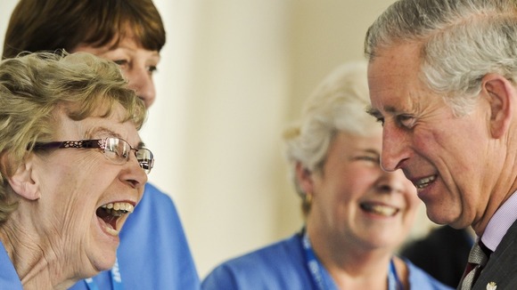 The Prince of Wales shares a joke with housekeeping assistant Roz Mesney at Dorset County Hospital