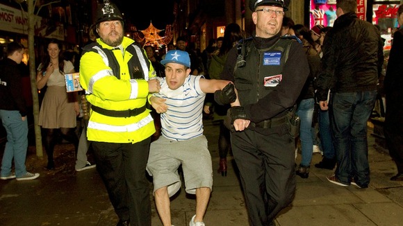 Lee Nelson's then carried off by the 'Policeman' and the CSO as the crowd looks on