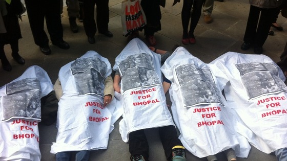 Protesters lie on the floor covered in sheets