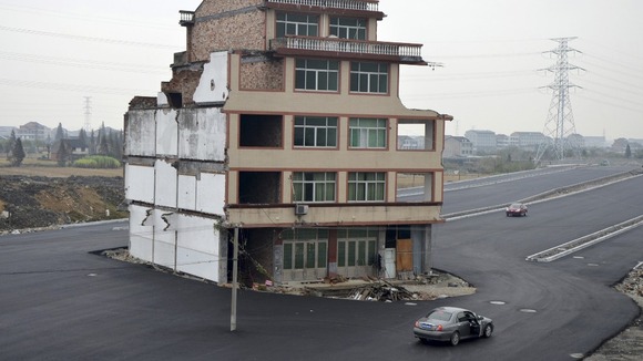 Car stops beside the house in the middle of a newly built road in Wenling