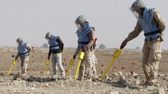 Members of the Iraqi Mine and Unexploded Ordnance Clearance Organization (IMCO) work to find mines in the Shatt-al-Arab district