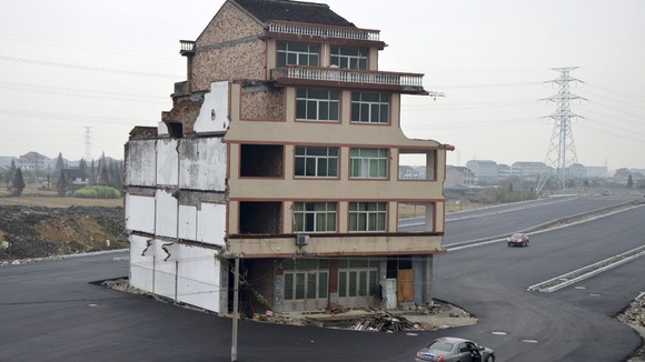Car stops beside the house in the middle of a newly built road in Wenling