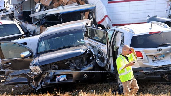 An emergency worker walks past a pile of cars from the accident on Interstate in Southeast Texas