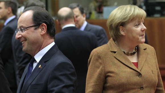 France's President Hollande walks past Germany's Chancellor Merkel
