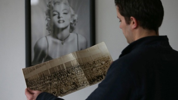 Auctioneer Paul Fairweather holds a copy of the image.