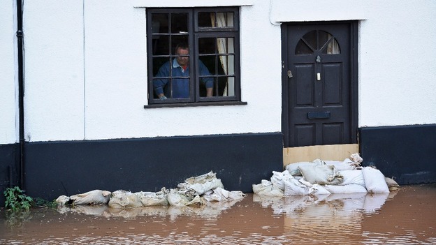 A resident checks the height of the flood outside his window.