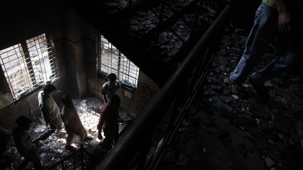 Workers visit a burnt garment factory after a devastating fire on the outskirts of Dhaka