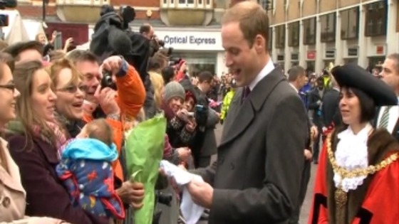 The Duke of Cambridge receives a gift from a member of the crowd.