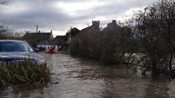Rescuers check on homes cut off by the floodwater.