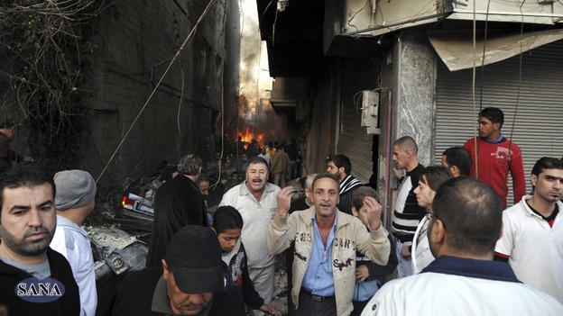 A crowd gathers at a site of a blast in Jaramana district, near Damascus