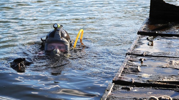 Able Seaman Diver Stuart Farden dives for the sunken swan nest raft.