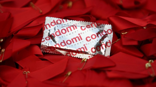 A pile of AIDs Day ribbons and a condom