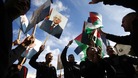 Palestinians in Ramallah hold placards depicting President Abbas during a rally in support of Abbas' efforts at the UN