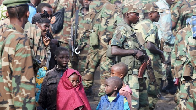 M23 rebels with local children in Karuba.