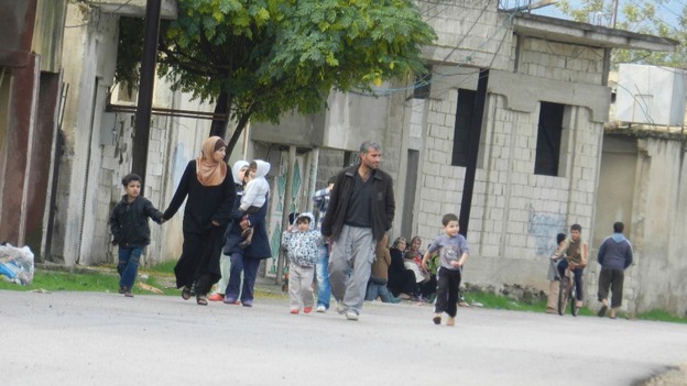 Residents flee their homes due to shelling at Houla, near Homs on November 18