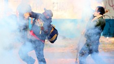Protesters hurl a gas canister at the police while engulfed in tear gas during protests against Mexico's President Enrique Pena Nieto.