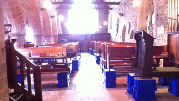 Pews propped up on boxes after flooding affected St Denys Church in Kempsey