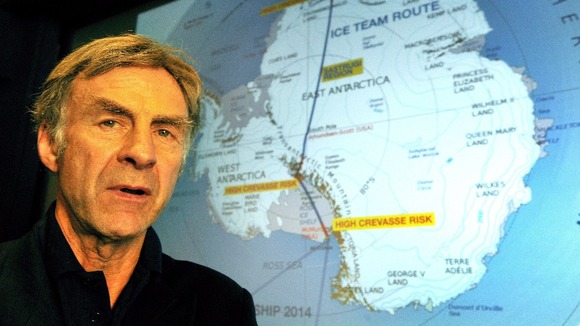 British explorer Sir Ranulph Fiennes stands in front of a projection that shows the route of the Coldest Journey on Earth.