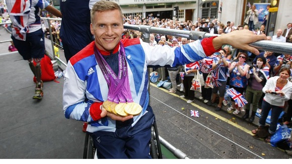 Quadruple gold medal winning Paralympian David Weir shows his medals as he takes part in the parade through London in September