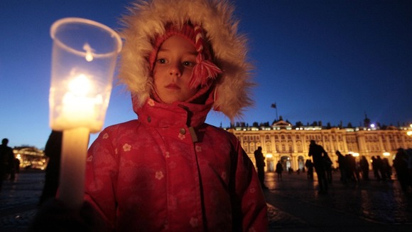 A child lights a candle in St Petersburg