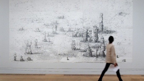 A member of the public walks past a large scale drawing by Paul Noble