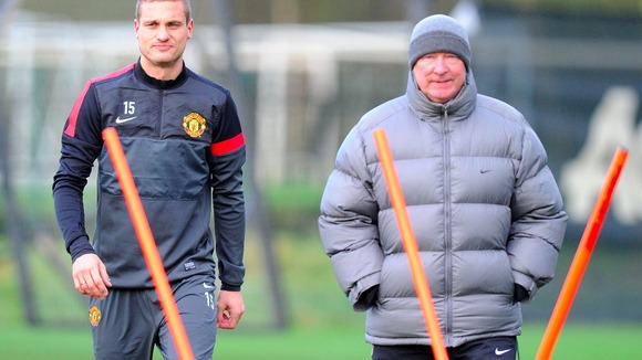 Nemanja Vidic and Sir Alex Ferguson keep warm in training