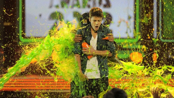 Will Smith hides behind Justine Bieber as he gets slimed at the 2012 Nickelodeon Kid's Choice awards