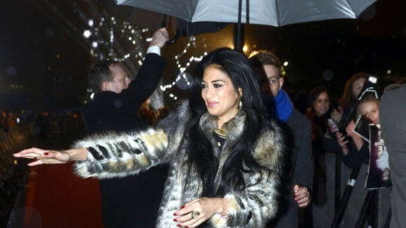 Nicole Scherzinger braves the rain to greet fans
