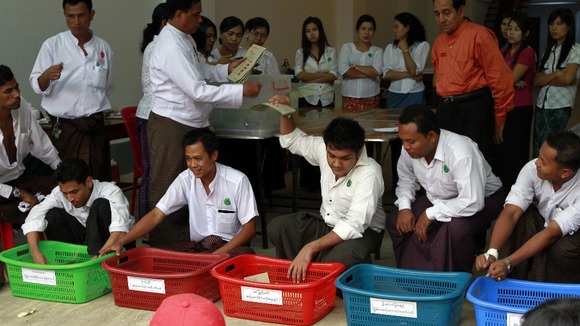 Officials count votes at a polling station in Dagon township in Yangon.