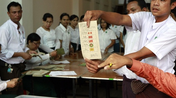 Officials show a ballot paper that shows a vote for Aung San Suu Kyi's National League for Democratic party.