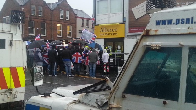 Protesters gather outside the offices of the Alliance Party in Belfast